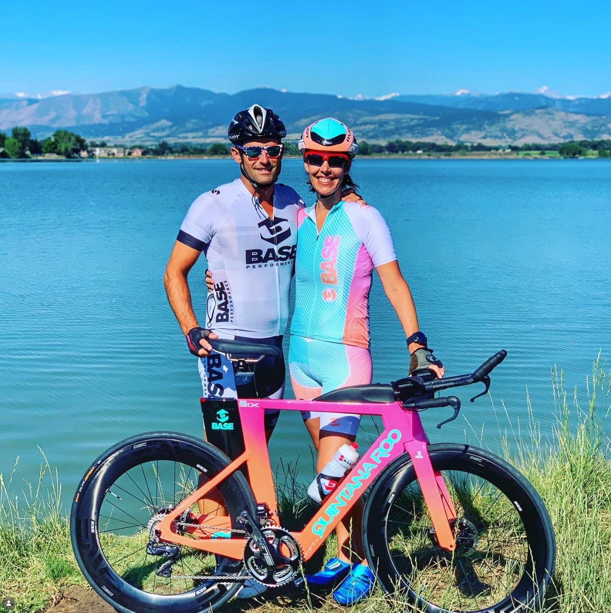 Matt Miller with a BASE Performance athlete and bikes beside a lake.